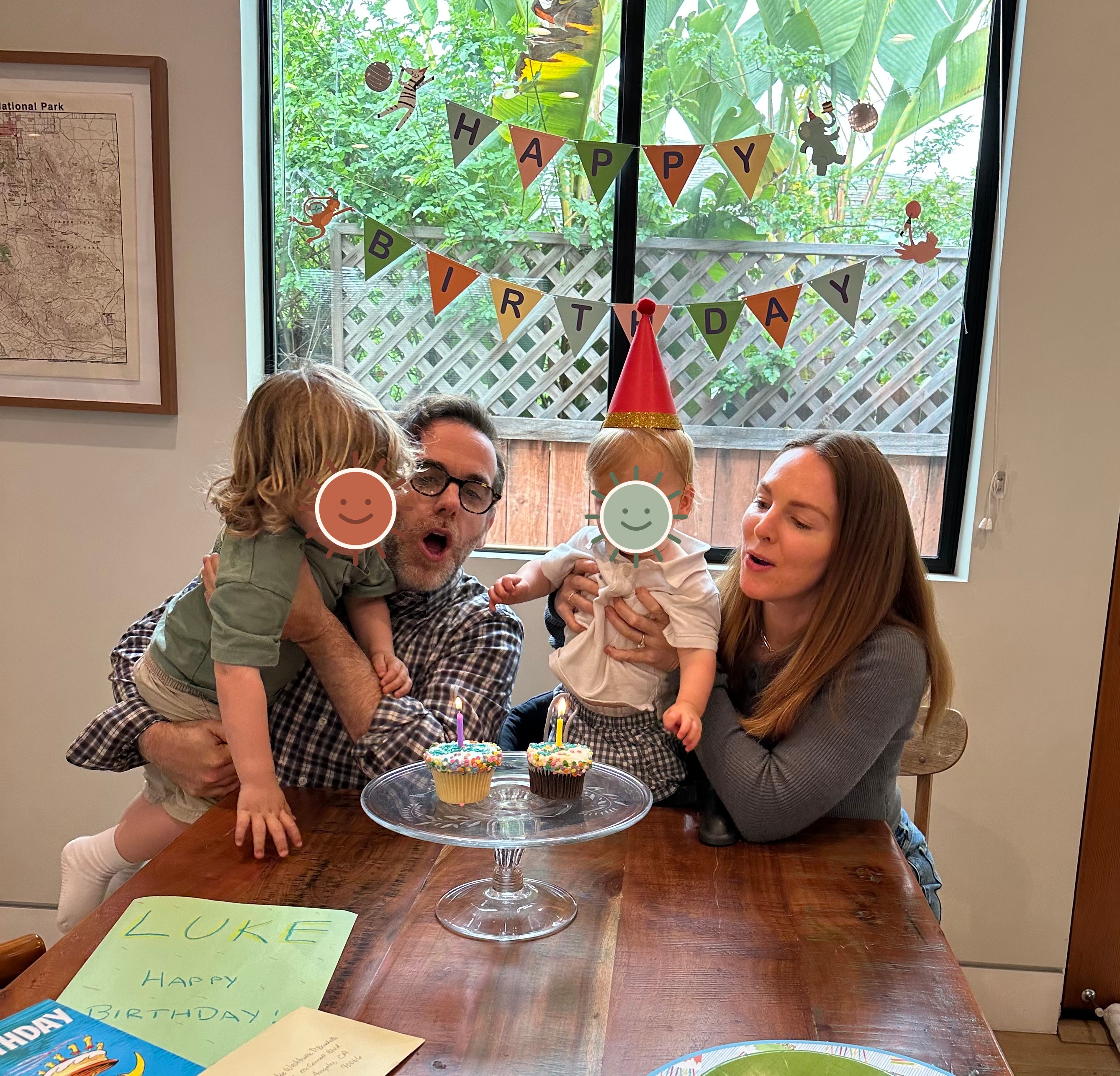 The family celebrating Luke's birthday with cupcakes, with the children's faces covered by illustrated stickers for privacy.